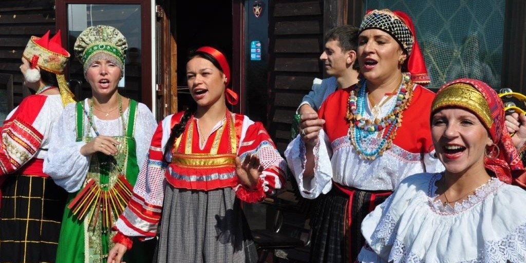 Traditionelles Brauchtum in Kaliningrad: vier Menschen singen ein traditionelles Lied und tragen traditionelle Trachten.