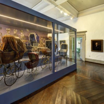 Eine Vitrine mit mit Kinderwagen im Kinderwagenmuseum Zeitz